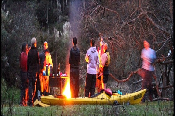 a group of people standing around a fire
